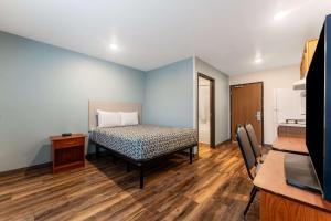 a small room with a bed and a kitchen at WoodSpring Suites Macon West I-475 in Macon