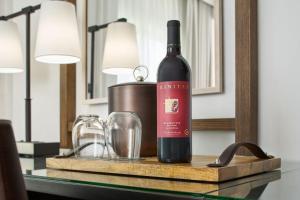 Grand Reserve at The Meritage في نابا: زجاجة من النبيذ موضوعة على طاولة مع كوب