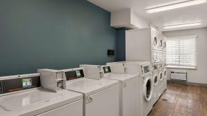 a laundry room with white washing machines and a window at WoodSpring Suites Evansville in Evansville