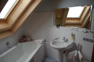 a bathroom with a sink and a bath tub at Liebevoll eingerichtete Ferienwohnung auf der zweiten Etage mit Balkon in Schönwald