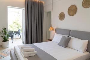 ein Schlafzimmer mit einem weißen Bett und einem großen Fenster in der Unterkunft SarandaView Hotel in Sarandë