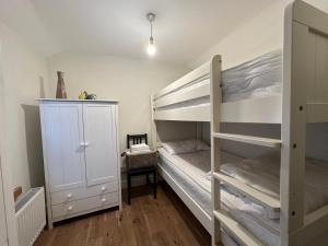 a bedroom with two bunk beds and a closet at The Cosy Cottage Retreat! Perfect for Contractors, Relocators, Getaway in Llantrisant