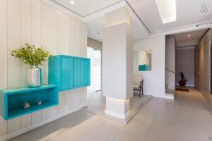 a hallway with a blue cabinet and a vase on a wall at Apartamento JURERE in Florianópolis