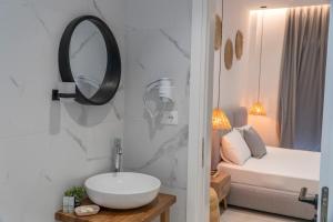 ein Bad mit einem Waschbecken, einem Spiegel und einem Bett in der Unterkunft SarandaView Hotel in Sarandë