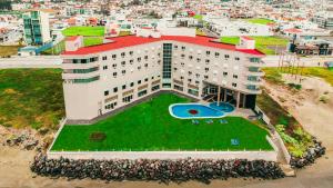 Un edificio con un césped verde delante. en Hilton Garden Inn Veracruz Boca del Rio, en Veracruz