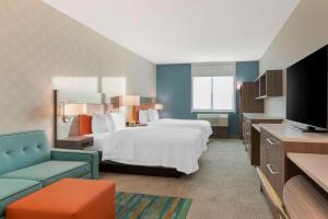 雷德兰兹Home2 Suites By Hilton Redlands的配有床和电视的酒店房间