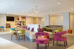 - un salon avec un canapé, des tables et des chaises dans l'établissement Home2 Suites By Hilton Clovis, à Clovis