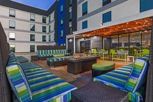un patio del hotel con tumbonas y mesas en Home2 Suites By Hilton Weatherford, en Weatherford