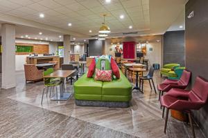 a waiting room with a green couch in the middle at Home2 Suites By Hilton Weatherford in Weatherford