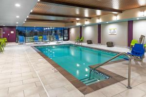 a pool in a hotel room with chairs and tables at Home2 Suites By Hilton Weatherford in Weatherford