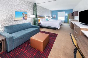 um quarto de hotel com um sofá e uma cama em Home2 Suites By Hilton Weatherford em Weatherford