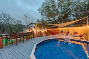 a deck with a pool and chairs and a table at Pool, Gameroom & Minigolf Enchanting Texas Home in San Antonio