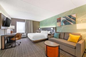 マディソンにあるComfort Inn & Suitesのベッドとソファ付きのホテルルーム