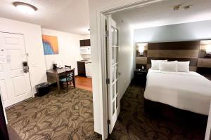 a hotel room with a bed and a desk at MainStay Suites Madison Airport in Madison