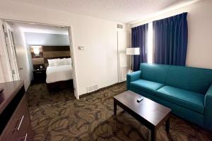 pokój hotelowy z kanapą i łóżkiem w obiekcie MainStay Suites Madison Airport w mieście Madison