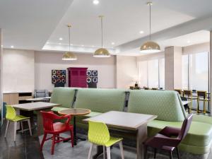 um restaurante com mesas e cadeiras verdes e vermelhas em Home2 Suites By Hilton Round Rock Medical Center em Round Rock