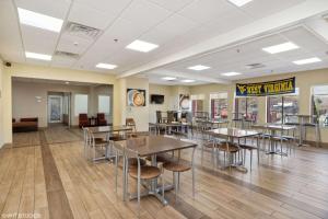 a dining area with tables and chairs in a cafeteria at Quality Inn & Suites in Morgantown