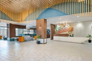 a lobby of a hotel with a large lobby with gold sticks at Cambria Hotel Nashville Midtown in Nashville