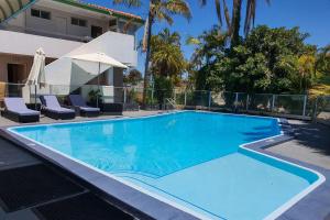 duży niebieski basen obok domu w obiekcie Econo Lodge Rivervale w mieście Perth