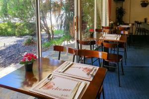 un restaurante con mesas de madera y sillas con flores. en Econo Lodge Rivervale, en Perth