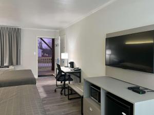 a hotel room with a bed and a flat screen tv at Mill Stream Country Inn in Smoketown