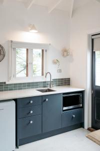 a kitchen with a sink and a microwave at Beach Huts Middleton in Middleton