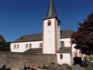 eine Kirche mit einem Kirchturm auf einer Mauer in der Unterkunft Ferienwohnung für 4 Personen ca 80 m in Niederehe, Rheinland-Pfalz Naturpark Vulkaneifel in Niederehe