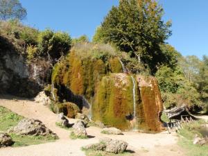 einen Wasserfall in einem Park mit Felsen und Bäumen in der Unterkunft Ferienwohnung für 4 Personen ca 80 m in Niederehe, Rheinland-Pfalz Naturpark Vulkaneifel in Niederehe