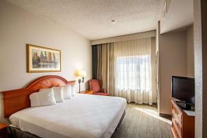 a hotel room with a bed and a television at Country Inn & Suites by Radisson, El Dorado, AR in El Dorado