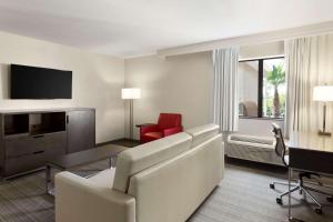 a living room with a couch and a table and a television at Country Inn & Suites by Radisson, Lackland AFB San Antonio , TX in San Antonio