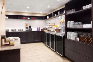 a kitchen with black cabinets and a counter with dishes at Country Inn & Suites by Radisson, Lackland AFB San Antonio, TX in San Antonio