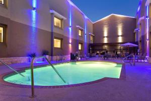 una piscina frente a un hotel con mesas y sillas en Country Inn & Suites by Radisson, Lackland AFB San Antonio , TX, en San Antonio