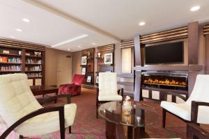 uma sala de estar com lareira e televisão em Country Inn & Suites by Radisson, San Carlos, CA em San Carlos