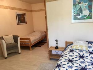 1 dormitorio con espejo, 1 cama y 1 silla en Gemütlicher Ferienbungalow mit Garten im ruhigen Naturgebiet en Hechthausen