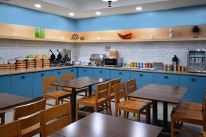 a restaurant with blue cabinets and wooden tables and chairs at Country Inn & Suites by Radisson Asheville West in Asheville