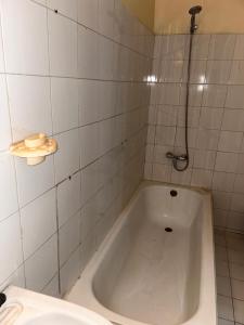 een witte badkamer met een bad en een wastafel bij Appartement meublé F4 Maristes, Dakar in Dakar