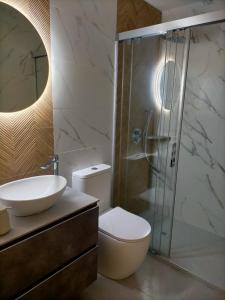 uma casa de banho com um WC, um lavatório e um chuveiro em Baeza aloja em Baeza