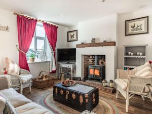 a living room with a fireplace and red curtains at 2 Bed in Holt 87768 in Baconsthorpe