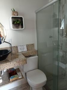 La salle de bains est pourvue de toilettes et d'une douche en verre. dans l'établissement Casa Aconchegante., à Cabo Frio