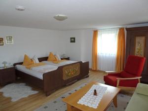 a bedroom with a bed and a red chair at Nette Wohnung in Garitz mit Garten, Terrasse und Grill in Bad Kissingen