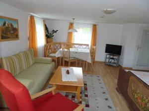 uma sala de estar com um sofá e uma mesa em Nette Wohnung in Garitz mit Garten, Terrasse und Grill em Bad Kissingen