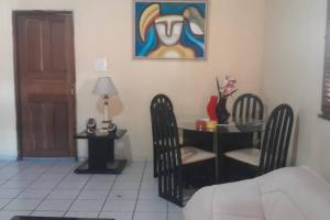 Zimmer mit einem Schreibtisch mit Stühlen und einem Tisch mit einem Gemälde in der Unterkunft Casa DOM Santo Amaro do Maranhão in Santo Amaro