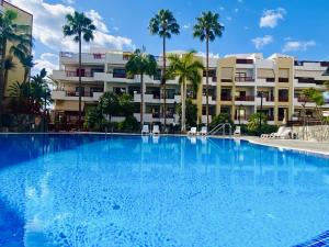 a large swimming pool in front of a building at PalmMar Balandros Deluxe By Deihu Experiences in Palm-mar