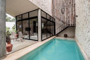 een huis met een zwembad en een groot raam bij 3BD Luxury Villa Private pool & with special fee to access Hotel Bardo 4B in Tulum
