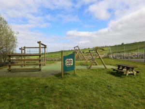 a playground with a sign and a picnic table at 2 Bed in Bassenthwaite SZ060 in Uldale