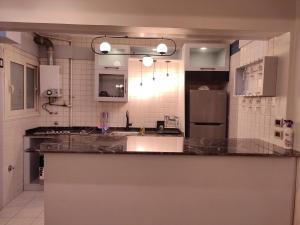 a kitchen with a counter top and a refrigerator at شقة فندقية فاخرة هادئة في القاهرة الدقي in Cairo