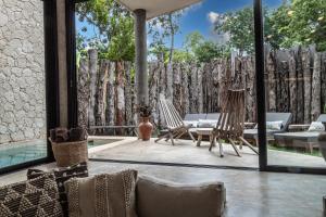 a patio with two chairs and a fence at 3BD Luxury Villa Private pool & with special fee to access Hotel Bardo 4B in Tulum