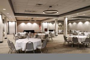 un salón de banquetes con mesas y sillas blancas en Holiday Inn Quincy, an IHG Hotel en Quincy