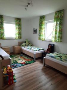 - une petite chambre avec 2 lits et un tapis dans l'établissement Ferienwohnung 2 Schlafzimmer Nähe Legoland Günzburg mit Balkon und herrlichem Fernblick, à Burtenbach