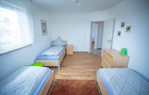 Cette chambre comprend 2 lits et une fenêtre. dans l'établissement Ferienwohnung 2 Schlafzimmer Nähe Legoland Günzburg mit Balkon und herrlichem Fernblick, à Burtenbach